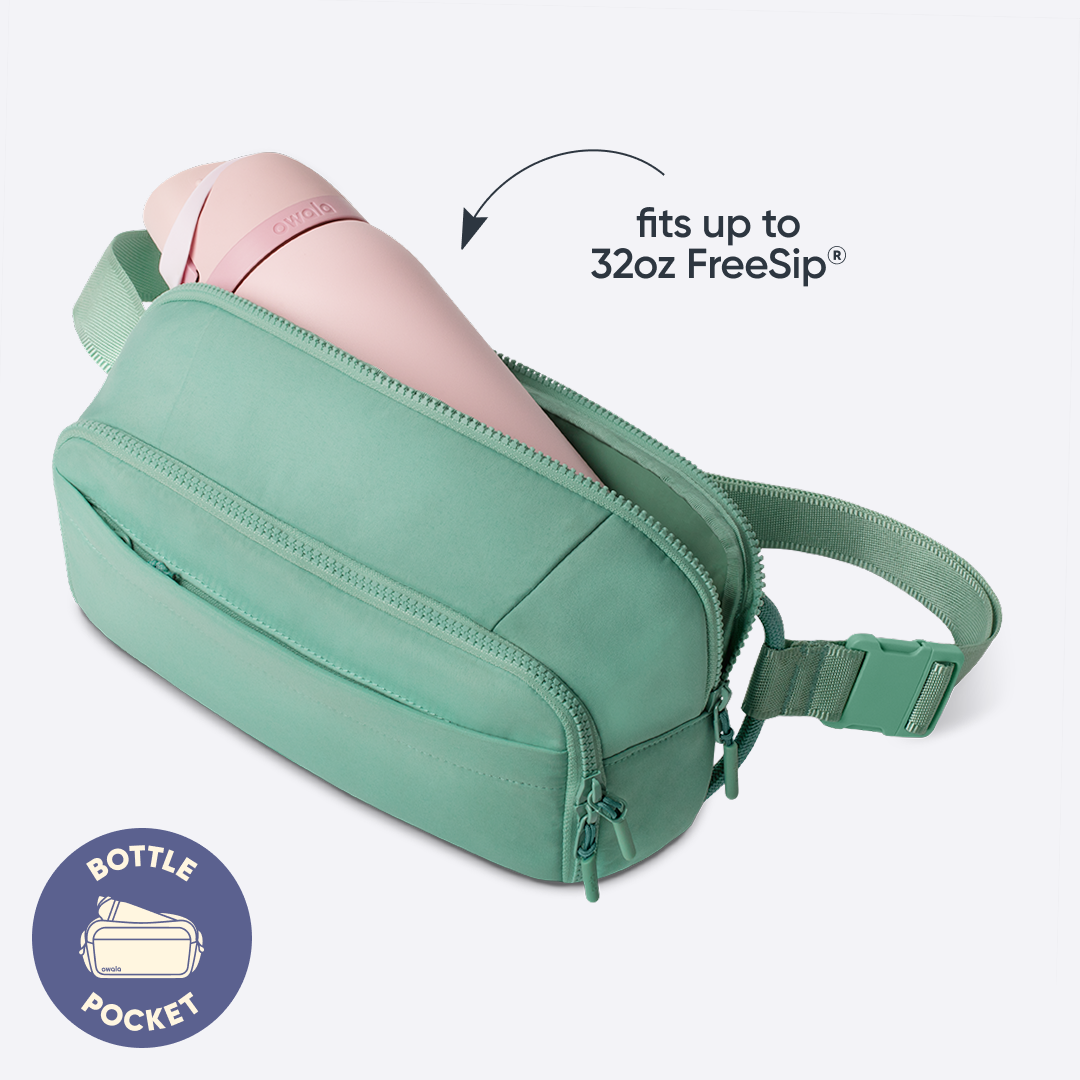 All-Day Crossbody in Sea Glass, mint green nylon belt bag interior with a pink FreeSip bottle tucked inside, with badge reading "BOTTLE POCKET" and text overlay reading "fits up to 32oz FreeSip"
